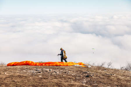 The paraglider prepares to jump from the top of the mountain. Somewhere high in the clouds.
