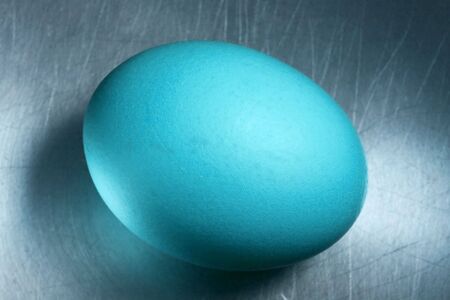 blue egg on scratched metallic surfaceの写真素材