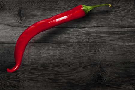 Red chili pepper isolated on wooden background.の写真素材