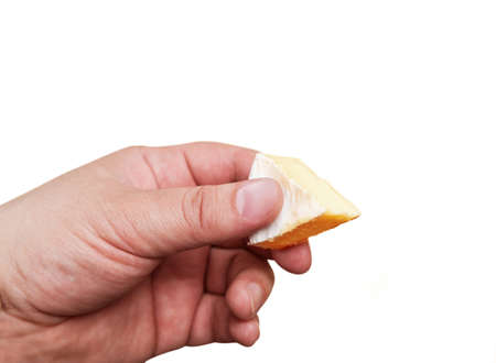 Slice of fresh natural cheese in a man's hand isolated on white backgroundの写真素材