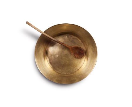 Old empty copper tray and wooden spoon. Isolated on white background.の写真素材