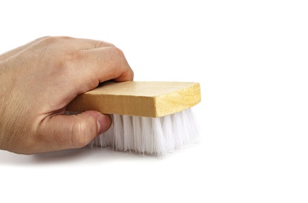 Brush for clothes in a mans hand close-up isolated on white