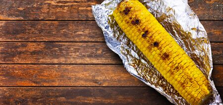 Tasty grilled corn on brown wooden tableの写真素材