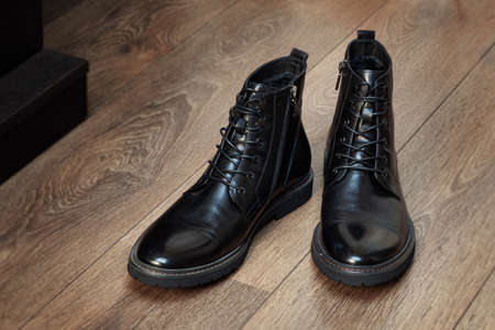 Black boots leather for men in the interior on a wooden floor isolated on white backgroundの写真素材