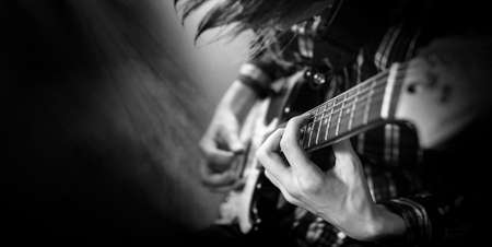 A young man playing ukulele. Black and white photography.