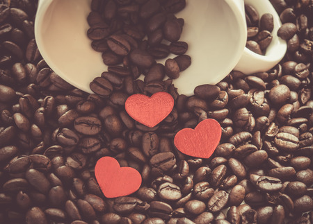 Coffee beans with red hearts and white cup.の写真素材