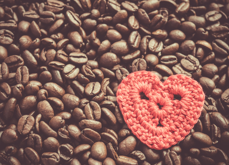 Coffee beans with red crocheted heart background.の写真素材