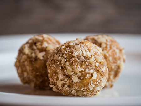 Detail of tasty homemade walnut balls on white plate, traditional Christmas sweets