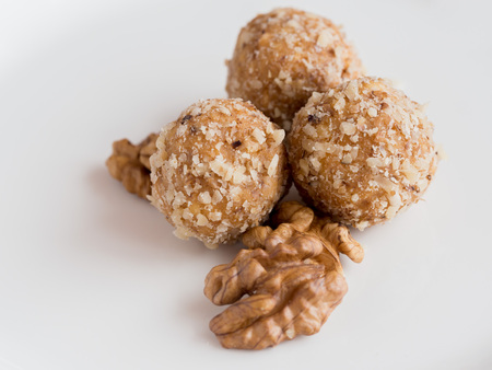 Detail of tasty homemade walnut balls and walnuts on white plate, traditional Christmas sweetsの写真素材