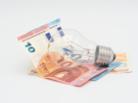 Euro banknotes and light bulb on white background, price increase of energy, savings ideaの写真素材
