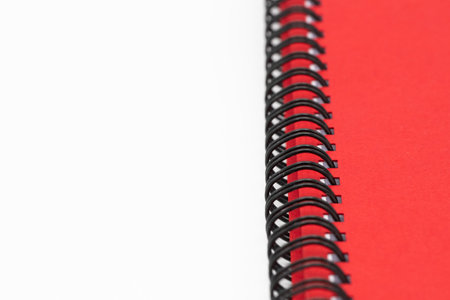 Close up of spiral notebook or notepad with red cover isolated on white backgroundの写真素材