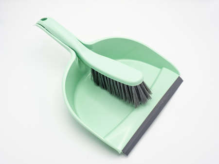 Small green plastic dustpan and shovel on white backgroundの写真素材