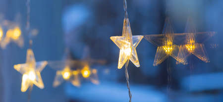 Detail of shining LED chain with stars, Christmas decoration hanging on windowの写真素材
