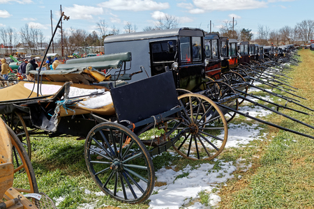 GORDONVILLE PENNSYLVANIA - March 11, 2017: Amish carriages for sale at annual spring auction `Amish Mud Sale` to benefit the Fire Company. Sale items include quilts, antiques, crafts, food, sporting goods, tools, farm equipment, and horses.のeditorial素材