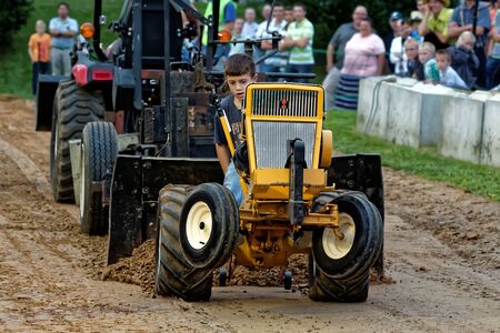 MYERSTOWN, PENNSYLVANIA - SEPTEMBER 14, 2018: A young boy drives a modified lawn tractor at Myerstown East End Days. The tractor pull is an annual community event.のeditorial素材