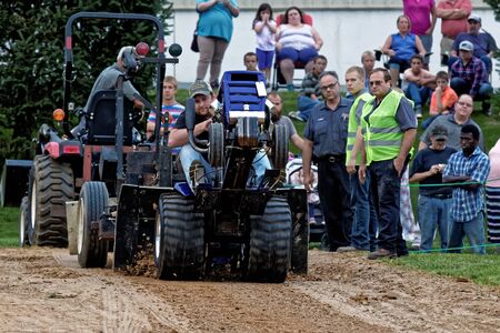 MYERSTOWN, PENNSYLVANIA - SEPTEMBER 14, 2018: A man drives a modified lawn tractor at Myerstown East End Days. The tractor pull is an annual community event.のeditorial素材