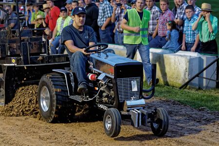 MYERSTOWN, PENNSYLVANIA - SEPTEMBER 14, 2018: A man drives a modified lawn tractor at Myerstown East End Days. The tractor pull is an annual community event.のeditorial素材