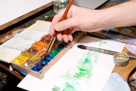 Hand of the artist drawing water color paintsの写真素材