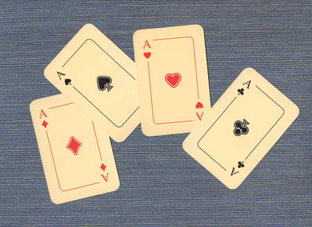 Four aces on blue textile background