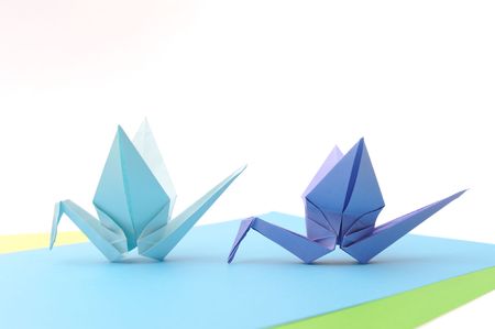 Origami birds over blue paper. Child paper articles.の写真素材