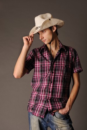 young man in cowboy hat on gray backgroundの写真素材