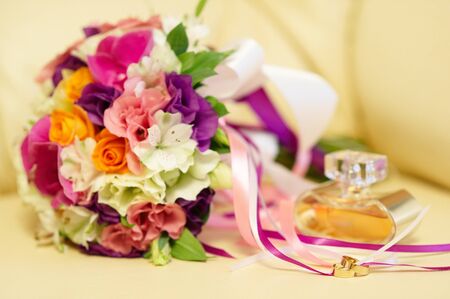 Wedding rings, bouquet and perfume, soft focus.の写真素材