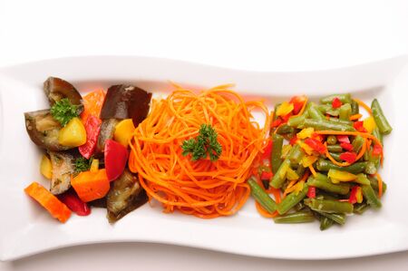 Different vegetable salads on a rectangular plate on white background.