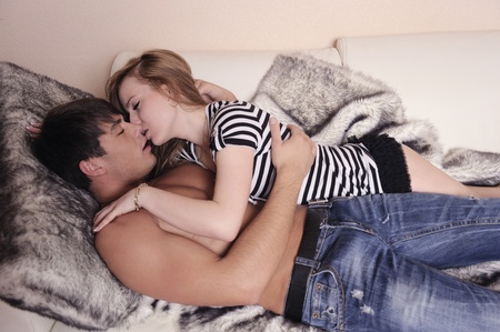 Kissing loving couple in the bedroom.の写真素材