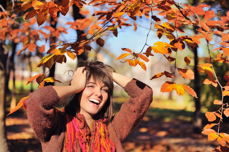 Happy smiling woman portrait in autumn park. の写真素材