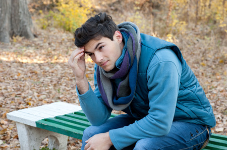 Portrait of young frustrated man thinking about the problems, autumn outdoor. の写真素材