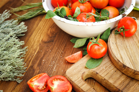 Organic cherry tomatoes in white bowl, authentic backgroundの写真素材