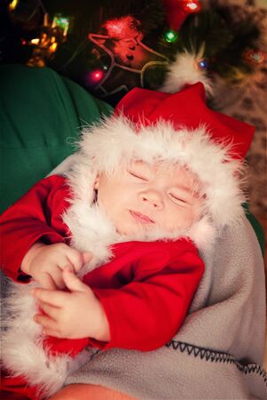 Beautiful sleeping newborn baby dressed in Santa Claus costumeの写真素材