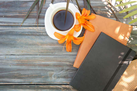 Morning mock up with coffee and notebooks on a wooden table, flat lay, outdoor summer photo with palm shadowsの写真素材