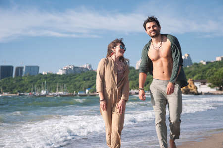 Smiling couple woman and man hiking by the sea costの写真素材