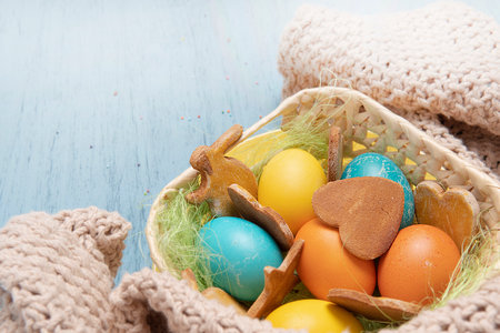 Basket with Easter colored eggs and holiday homemade cookies