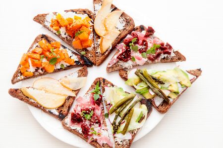 Assorted bruschetta with various toppings. Variety of small sandwiches. Mix bruschetta. Party...