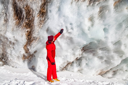 Young man in red hat enjoys sunny day in mountainsの写真素材