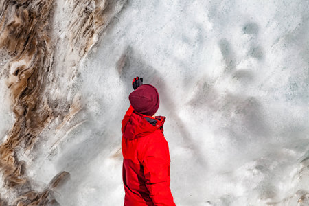 Young man in red hat enjoys sunny day in mountainsの写真素材