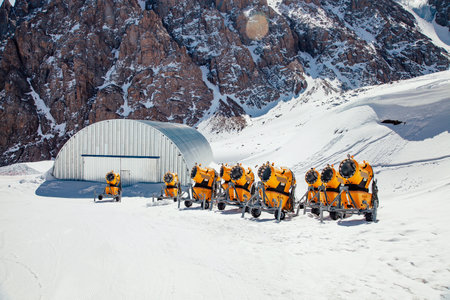 Group of yellow snow cannons are waiting for the start of the ski season in the mountains