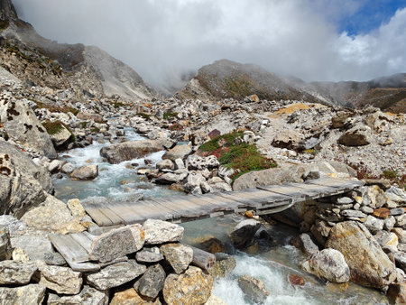 Small wooden bridge across the river in the mountains.の写真素材