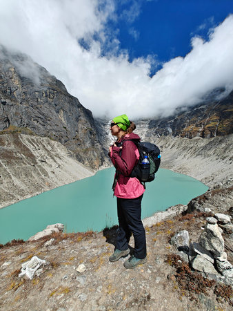 Woman in pink jacket near beautiful mountain lake