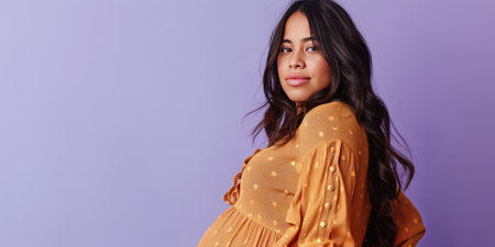 A confident pregnant woman with long dark hair wears a stylish mustard yellow dress, posing against a lavender background. She exudes elegance and warmth, embodying the beauty of motherhood.の素材