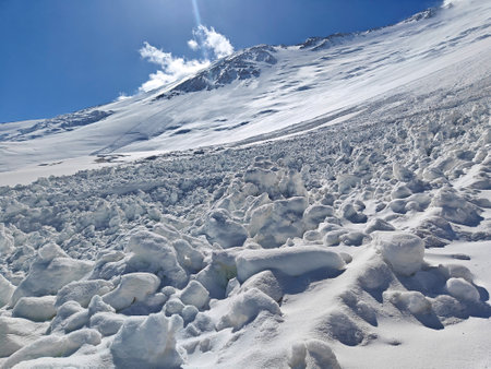 Snow and ice blanket the mountains, glistening in the sun under clear skies, showing stunning...