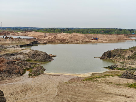 Yellow-orange toxic waste in water in sandpit. Ecology concept.