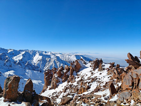 Snow-covered peaks rise magnificently against a bright blue sky, highlighting the beauty of untouched alpine terrain.の写真素材