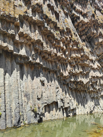 Symphony of Stones in Armenia, a natural rock formation with stunning basalt columns reflecting in calm water.の写真素材