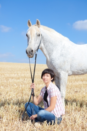 Smiling Young Woman Posing With Her Horseの写真素材