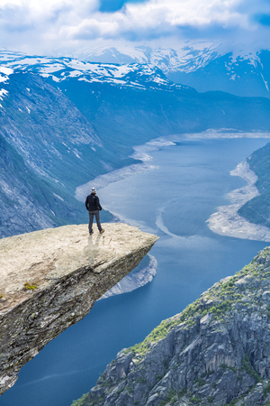 Woman On Trolltunga - 
View On Norway Mountain Landscape From Trolltunga - The Troll's tongue in Odda, Ringedalsvatnet Lake,  Norway).の写真素材