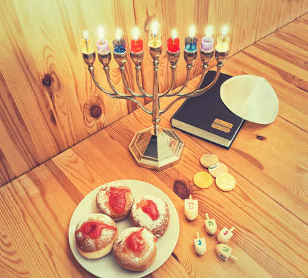 Jewish Holiday Hanukkah With Silver Menorah (traditional candelabra) with Burning candles, Torah, Donuts And Wooden Dreidels,の写真素材