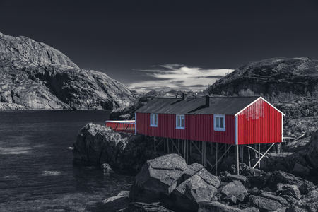 Red Classic Norwegian Rorbu fishing huts with sod roof on Lofoten islands, Nusfjord. Norwegian traditional type of house used by fishermen - Black And White Toned
の写真素材